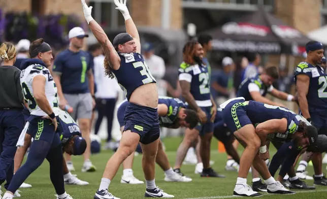 Seattle Seahawks fullback Brady Russell (38) stretches with teammates during the NFL football team's training camp Friday, July 25, 2025, in Renton, Wash. (AP Photo/Lindsey Wasson)