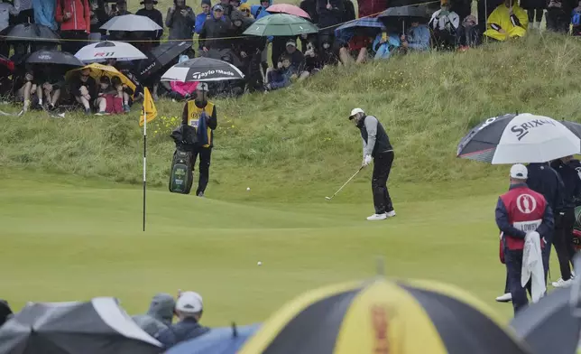 Scottie Scheffler of the United States chips onto the 8th green during the first round of the British Open golf championship at the Royal Portrush Golf Club, Northern Ireland, Thursday, July 17, 2025. (AP Photo/Jon Super)