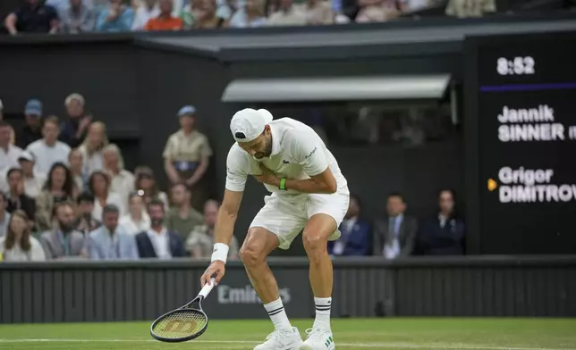 Bulgaria's Grigor Dimitrov clutches his chest with an injury which forced him to retire injured from a fourth round men's singles match against Italy's Jannik Sinner at the Wimbledon Tennis Championships in London, Monday, July 7, 2025. (AP Photo/Kin Cheung)