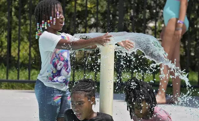 Children play in the water to avoid the heat at the Titusville Splash Pad, Tuesday, July 29, 2025, in Titusville, Fla. (AP Photo/Chris O'Meara)
