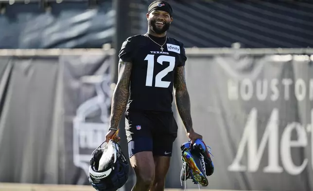 Houston Texans wide receiver Nico Collins smiles as he arrives for the team's NFL football training camp Wednesday, July 23, 2025, in Houston. (AP Photo/Ashley Landis)