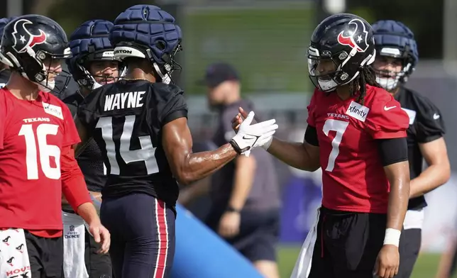 Houston Texans wide receiver Jared Wayne (14) greets quarterback C.J. Stroud (7) during the team's NFL football training camp Wednesday, July 23, 2025, in Houston. (AP Photo/Ashley Landis)