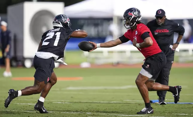 Houston Texans quarterback C.J. Stroud, right, hands off to runningback Nick Chubb (21) during the team's NFL football training camp Wednesday, July 23, 2025, in Houston. (AP Photo/Ashley Landis)