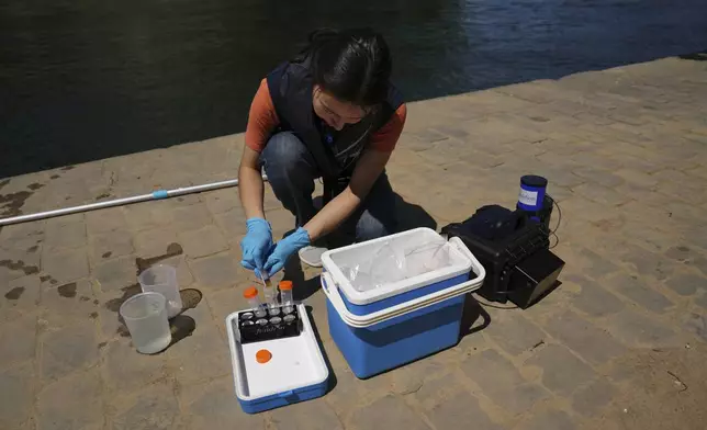 Emilie Vilana of Fluidion test the Seine river water quality, Thursday, July 3, 2025 for the opening of the three Seine swimming pools during the 'Paris Plages' event from July 5 to Aug. 31 in Paris. (AP Photo/Aurelien Morissard)