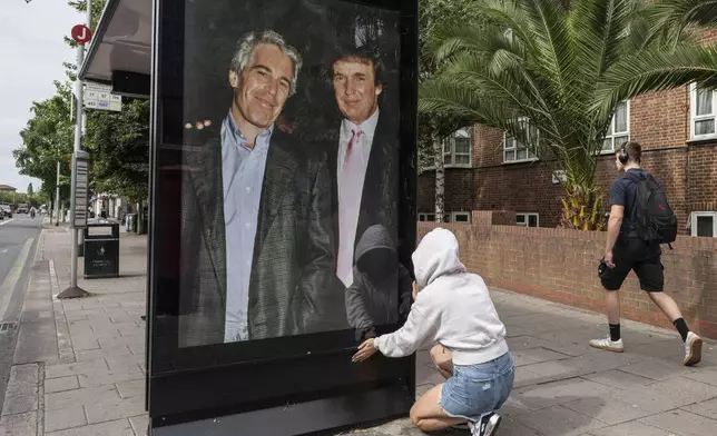 Activists put up a poster showing President Donald Trump and Jeffrey Epstein near the U.S. Embassy in London, Thursday, July 17, 2025.(AP Photo/Thomas Krych)