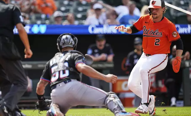 Baltimore Orioles' Gunnar Henderson (2) is tagged out at home plate by Miami Marlins catcher Agustin Ramirez (50) during the first inning of a baseball game, Saturday, July 12, 2025, in Baltimore. (AP Photo/Stephanie Scarbrough)