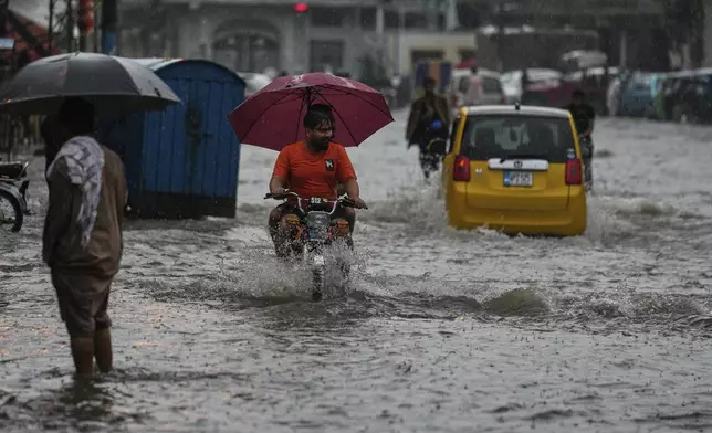 Motorists drive through a flooded road during monsoon rainfall, in Rawalpindi, Pakistan, Thursday, July 17, 2025. (AP Photo/Anjum Naveed)