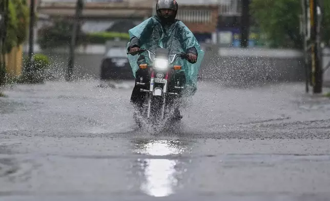 A motorcyclist rides through a flooded road during monsoon rainfall, in Rawalpindi, Pakistan, Thursday, July 17, 2025. (AP Photo/Anjum Naveed)