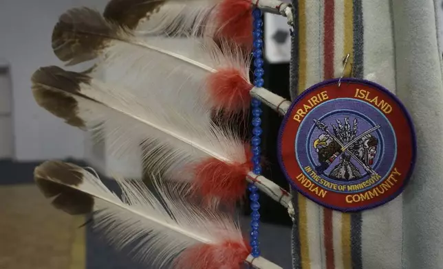 A ceremonial staff with eagle feathers stands near the podium at a ceremony honoring high school and higher education graduates at the Prairie Island Indian Community in Minnesota on Wednesday, July 9, 2025. (AP Photo/Giovanna Dell'Orto)