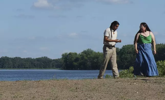 Derek Walking Eagle walks by the Mississippi River before attending a ceremony honoring high school graduates by presenting them with a bald eagle feather at the Prairie Island Indian Community in Minnesota on Wednesday, July 9, 2025. (AP Photo/Giovanna Dell'Orto)