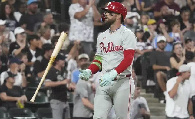 Philadelphia Phillies' Bryce Harper flips his bat as he pops out to Chicago White Sox third baseman Colson Montgomery in foul territory during the seventh inning of a baseball game in Chicago, Monday, July 28, 2025. (AP Photo/Nam Y. Huh)