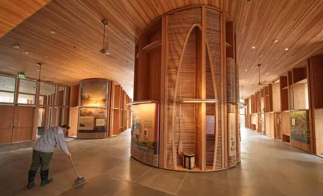 A national park employee sweeps the floor in the Tekakapimək Contact Station, Jan. 7, 2025, at the Katahdin Woods and Waters Monument in northern Maine. (AP Photo/Robert F. Bukaty)