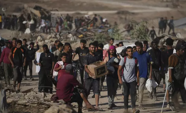 Palestinians carry humanitarian aid packages near the Gaza Humanitarian Foundation distribution center operated by the U.S.-backed organization in Khan Younis, southern Gaza Strip, Thursday, June 26, 2025. (AP Photo/Abdel Kareem Hana)