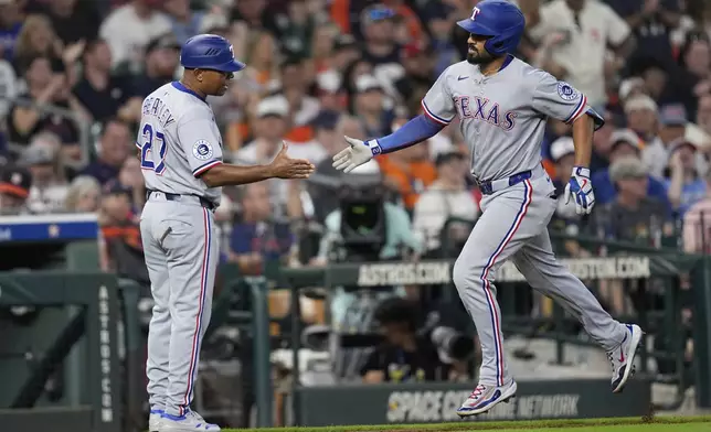 Texas Rangers' Marcus Semien, right, celebrates with third base coach Tony Beasley after hitting a home run against the Houston Astros during the eighth inning of a baseball game Sunday, July 13, 2025, in Houston. (AP Photo/David J. Phillip)
