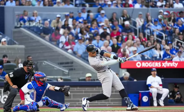 New York Yankees' Aaron Judge, front right, strikes out against the Toronto Blue Jays during first-inning baseball game action in Toronto, Monday, July 21, 2025. (Thomas Skrlj/The Canadian Press via AP)