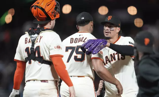 San Francisco Giants' Patrick Bailey, from left, celebrates with Camilo Doval (75) and Willy Adames after a baseball game against the Philadelphia Phillies in San Francisco, Monday, July 7, 2025. (AP Photo/Jeff Chiu)