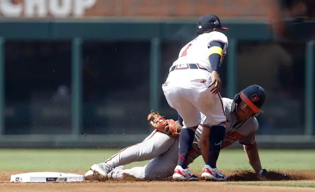 Baltimore Orioles' Jackson Holliday (7) is tagged out by Atlanta Braves second baseman Ozzie Albies (1) as he tries to steal second base during the first inning of a baseball game, Sunday, July 6, 2025, in Atlanta. (AP Photo/Butch Dill)
