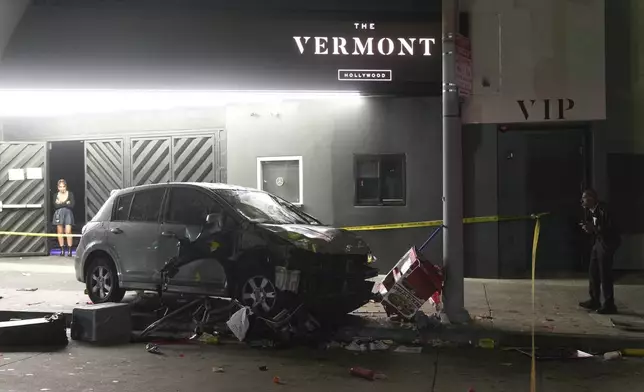 A vehicle sits on the sidewalk after ramming into a crowd of people waiting to enter a nightclub along a busy boulevard in Los Angeles early Saturday, July 19, 2025 injuring several people. (AP Photo/Damian Dovarganes)