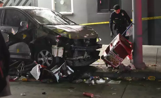 A vehicle sits on the sidewalk after ramming into a crowd of people waiting to enter a nightclub along a busy boulevard in Los Angeles early Saturday, July 19, 2025 injuring several people. (AP Photo/Damian Dovarganes)