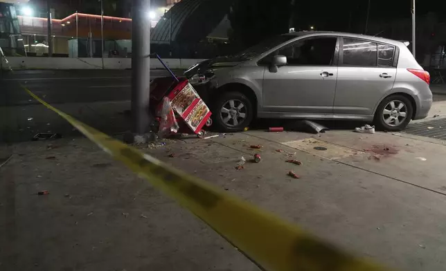 A vehicle sits on the sidewalk after ramming into a crowd of people waiting to enter a nightclub along a busy boulevard in Los Angeles early Saturday, July 19, 2025 injuring several people. (AP Photo/Damian Dovarganes)