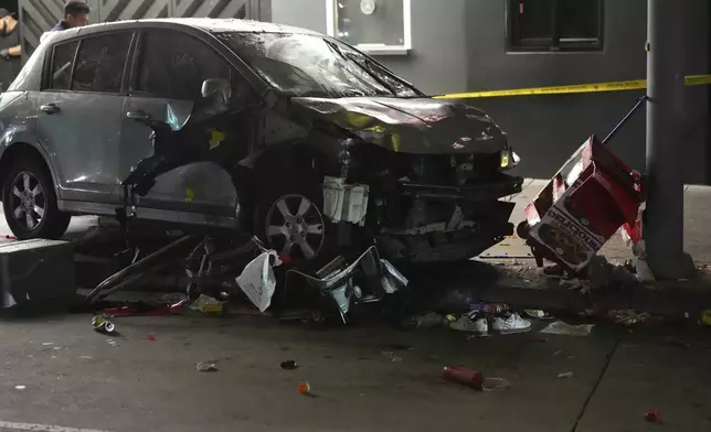 A vehicle sits on the sidewalk after ramming into a crowd of people waiting to enter a nightclub along a busy boulevard in Los Angeles early Saturday, July 19, 2025 injuring several people. (AP Photo/Damian Dovarganes)