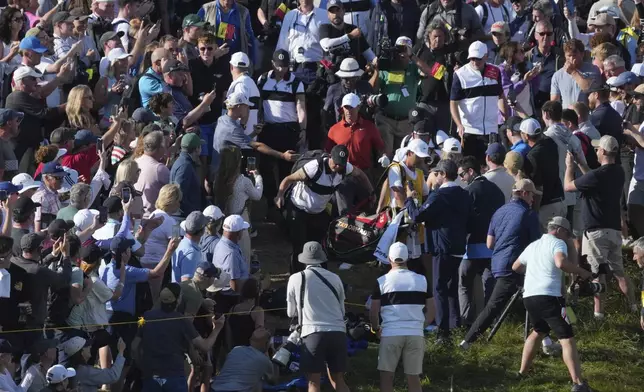 Rory McIlroy of Northern Ireland goes to his ball on the 17th which landed win the crowd during the third round of the British Open golf championship at the Royal Portrush Golf Club, Northern Ireland, Saturday, July 19, 2025. (AP Photo/Jon Super)