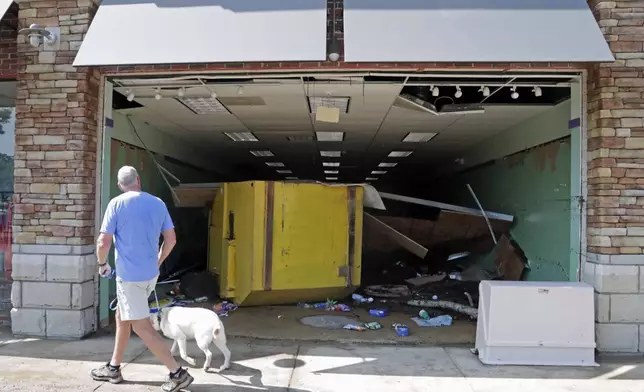 A floating garbage container crashed through the front of this business in the Eastgate Shopping Center after it was flooded during tropical storm Chantal, Monday, July 7, 2025, in Chapel Hill, N.C. (AP Photo/Chris Seward)