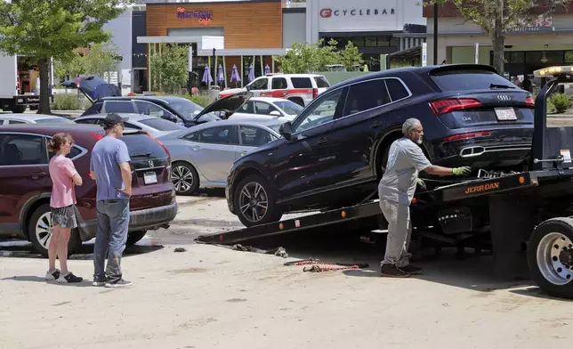 Dozens of cars were towed from a parking lot at University Place shopping center after they were flooded out during tropical storm Chantal, Monday, July 7, 2025, in Chapel Hill, N.C. (AP Photo/Chris Seward)
