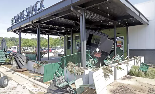 Chairs, umbrellas and a larger garbage container were among the debris washed up at the Shake Shack in the Eastgate Shopping Center after it was flooded during tropical storm Chantal, Monday, July 7, 2025, in Chapel Hill, N.C. (AP Photo/Chris Seward)