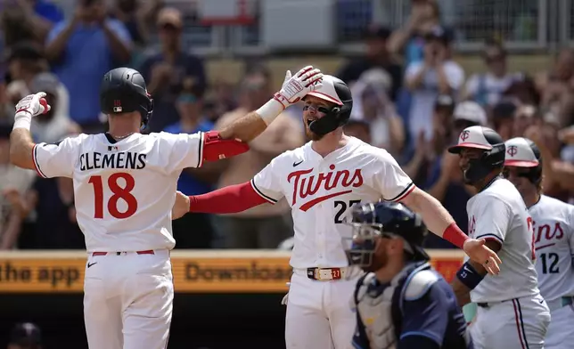 Minnesota Twins' Kody Clemens (18) celebrates with Ryan Jeffers (27) after hitting a three-run home run during the sixth inning of a baseball game against the Tampa Bay Rays, Saturday, July 5, 2025, in Minneapolis. (AP Photo/Abbie Parr)