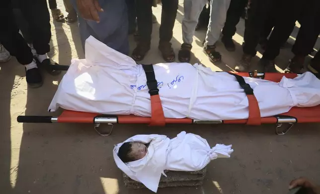 Mourners pray over the body of Soad Qeshtah, who died hours after being delivered by emergency caesarean section from her mother, seven-months pregnant Soad al-Shaer, killed in an overnight Israeli airstrike on Khan Younis in the Gaza Strip, Monday, July 28, 2025. (AP Photo/Mariam Dagga)