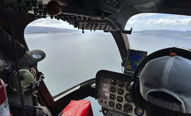 Crew fly a helicopter flying over the Bali Strait during a search operation for the victims of a late Wednesday ferry sinking near the resort island of Bali, Indonesia, Friday, July 4, 2025. (AP Photo/Firdia Lisnawati)
