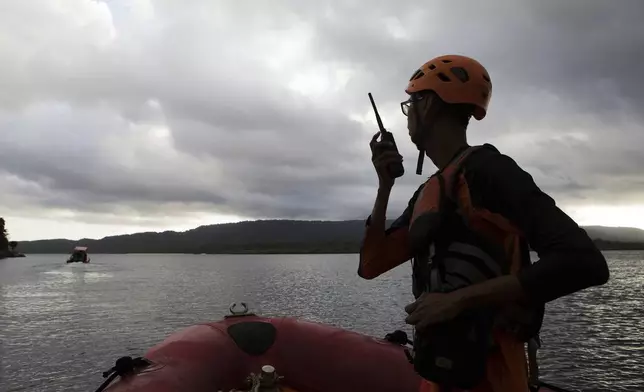 A member of the National Search and Rescue Agency (BASARNAS) talks on his radio during a search search for the victims of a sunken ferry in the waters off Jembrana, Bali, Indonesia, Friday, July 4, 2025. (AP Photo/Firdia Lisnawati)