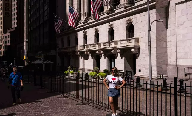 A tourist takes a picture in front of the New York Stock Exchange on Monday, June 30, 2025, in New York. (AP Photo/Yuki Iwamura)