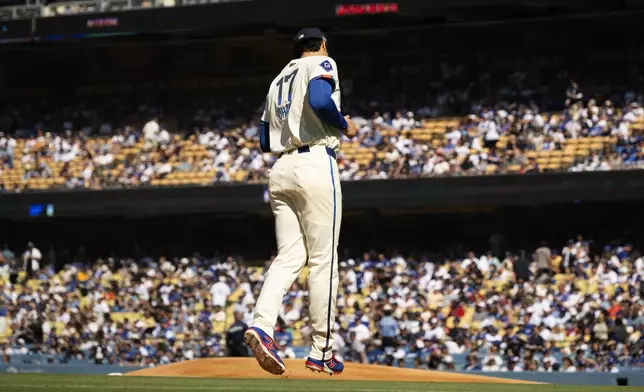 Los Angeles Dodgers starting pitcher Shohei Ohtani jogs out to the mound before a baseball game against the Houston Astros in Los Angeles, Saturday, July 5, 2025. (AP Photo/Kyusung Gong)