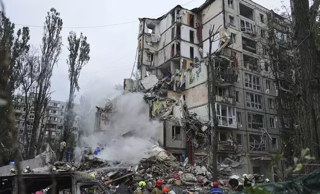 Rescuers work in a destroyed apartment building after a Russian missile attack in Kyiv, Ukraine, Thursday, July 31, 2025. (AP Photo/Efrem Lukatsky)