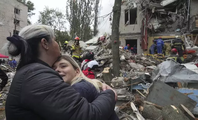 Women react outside a destroyed apartment building after a Russian missile attack in Kyiv, Ukraine, Thursday, July 31, 2025. (AP Photo/Efrem Lukatsky)