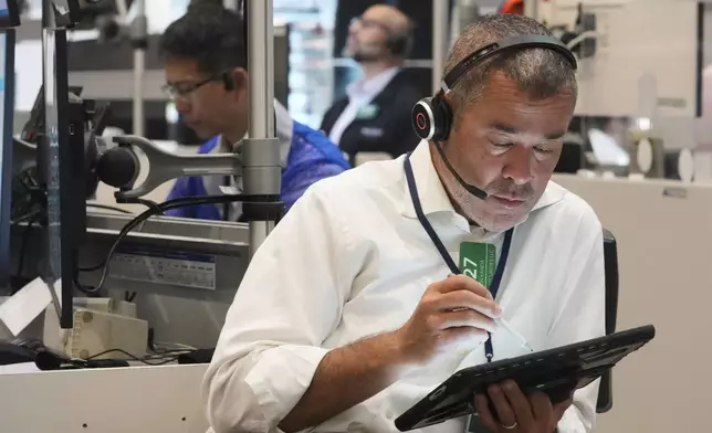 Options trader Justin Kanda, right, works on the floor of the New York Stock Exchange, Tuesday, July 8, 2025. (AP Photo/Richard Drew)
