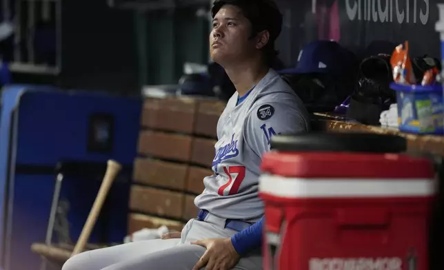 Los Angeles Dodgers' Shohei Ohtani sits in the dugout during the fourth inning of a baseball game against the Cincinnati Reds Wednesday, July 30, 2025, in Cincinnati. (AP Photo/Carolyn Kaster)