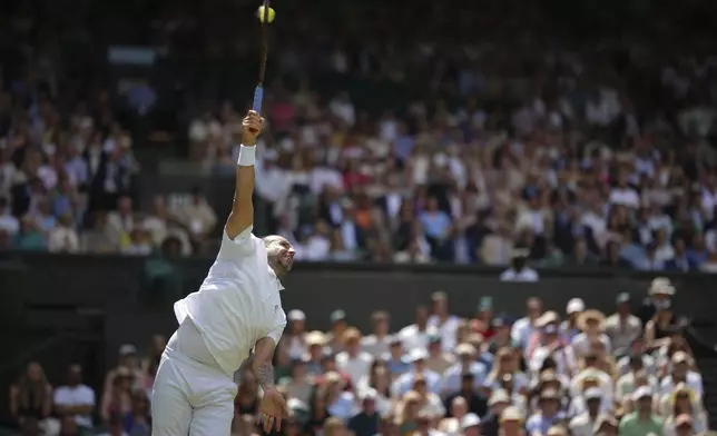 Daniel Evans of Britain serves to Novak Djokovic of Serbia during their second round men's singles match at the Wimbledon Tennis Championships in London, Thursday, July 3, 2025. (AP Photo/Alastair Grant)