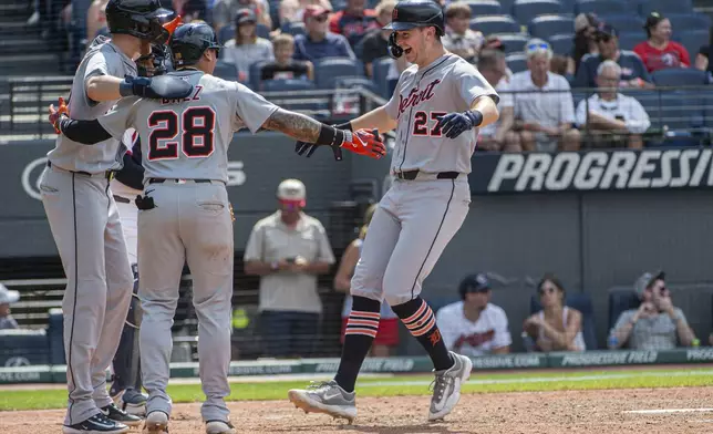 Detroit Tigers' Parker Meadows, left, and Javier Baez (28) congratulate Trey Sweeney (27) after his three-run home run off Cleveland Guardians relief pitcher Cade Smith during the 10th inning of a baseball game, Sunday, July 6, 2025, in Cleveland. (AP Photo/Phil Long)