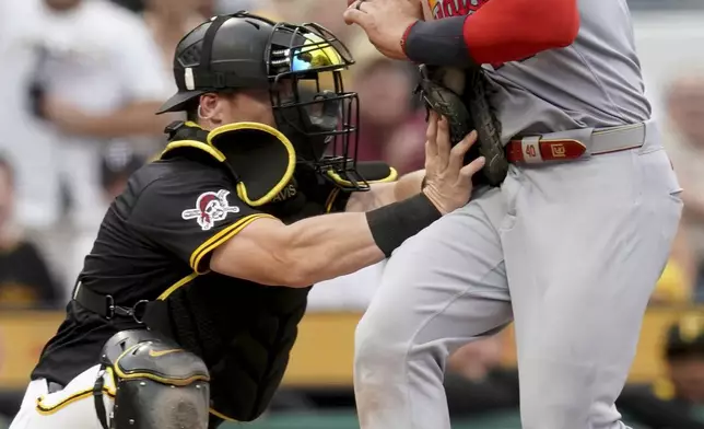 Pittsburgh Pirates catcher Henry Davis, left, tags out St. Louis Cardinals' Willson Contreras, right, at home during the fourth inning of a baseball game, Tuesday, July 1, 2025, in Pittsburgh. (AP Photo/Matt Freed)