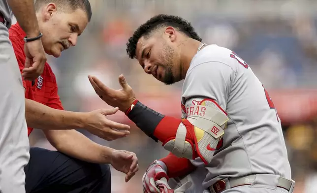 St. Louis Cardinals' Willson Contreras, right, is examined by a team trainer after getting hit by a pitch by Pittsburgh Pirates pitcher Paul Skenes during the fourth inning of a baseball game, Tuesday, July 1, 2025, in Pittsburgh. (AP Photo/Matt Freed)