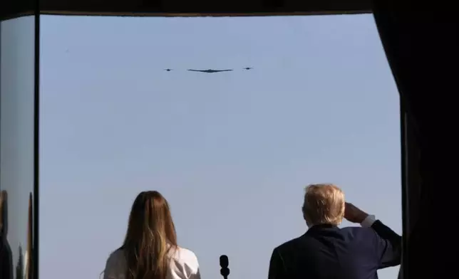 President Donald Trump, right, and first lady Melania Trump observe as B-2 Spirit stealth bombers perform a military flyover from the Blue Room balcony of the White House during a Fourth of July celebration in Washington, Friday, July 4, 2025. (AP Photo/Alex Brandon, Pool)