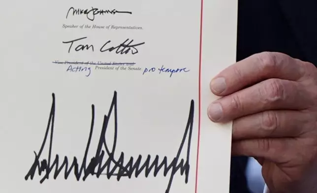 President Donald Trump holds his signed his signature bill of tax breaks and spending cuts at the White House, Friday, July 4, 2025, in Washington. (AP Photo/Julia Demaree Nikhinson)