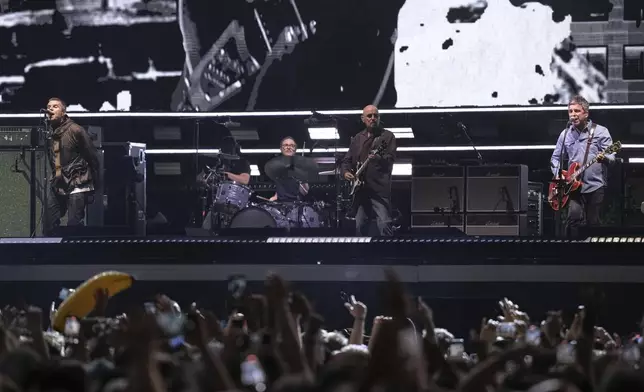 Liam Gallagher, left, and Noel Gallagher, right, from the band Oasis perform during their reunion concert on Friday, July 4, 2025, in Cardiff. (Photo by Scott A Garfitt/Invision/AP)