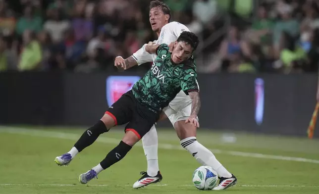 Liga MX All-Stars' Alejandro Zendejas, left, falls as he and MLS All-Stars' Guilherme Biro, right, compete for the ball during the MLS All-Star soccer match in Austin, Texas, Wednesday, July 23, 2025. (AP Photo/Eric Gay)