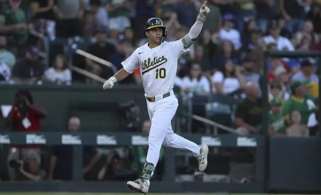 Athletics' Max Muncy points to the dugout after hitting a two-run home run during the first inning of a baseball game against the Atlanta Braves, Tuesday, July 8, 2025, in West Sacramento, Calif. (AP Photo/Scott Marshall)