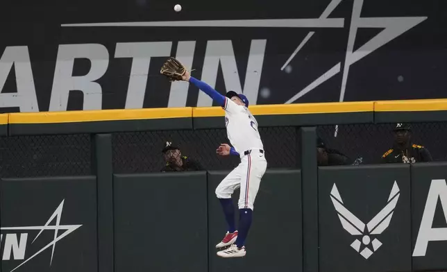 Texas Rangers center fielder Michael Helman makes a leaping catch on a fly out by the Athletics' Tyler Soderstrom in the sixth inning of a baseball game, Wednesday, July 23, 2025, in Arlington, Texas. (AP Photo/Tony Gutierrez)