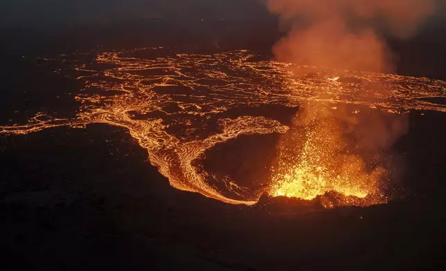 Lava flows next to the northern crater after a volcanic eruption around 6 kilometers (3.7 miles) north of Grindavik, Iceland, on the Reykjanes Peninsula, Saturday, July 19, 2025. (AP Photo/Marco di Marco)